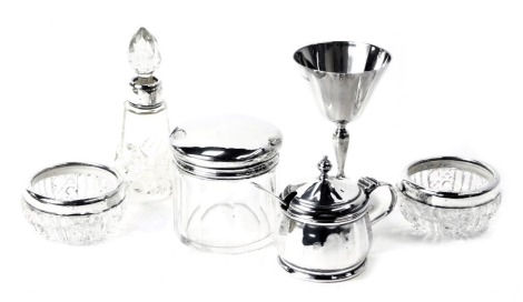 Silver dressing table wares, comprising a circular topped George V dressing table jar, 5cm high, cut glass scent bottle with silver collar, 5.5cm high, two silver collared salts, a George VI Mappin and Webb silver cruet with preserve spoon and blue glass 