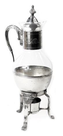 An early 20thC French silver plated claret jug, with foliate engraved collar, glass bowl and rim, on spirit kettle base, scroll decoration, 42cm high.