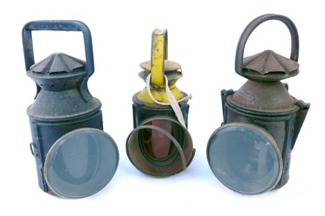 Three railway inspection lanterns, comprising a yellow painted BR example with orange concave face glass, 31cm high, and another two unmarked, 34cm high. (3)