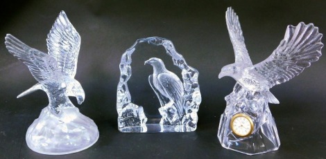 Decorative Art Glass, comprising a Mats Jonasson Intaglio glass eagle paperweight, a cut glass eagle mantel clock, and an eagle on rocky mound, 18cm, 23cm and 22cm high. (3)