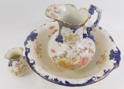 A late 19thC pottery wash jug and bowl set, toothbrush holder, each decorated with flowers picked out in gilt. (3) - 2