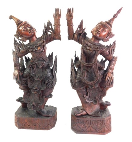 A pair of early 20thC carved South East Asian Yaksha carved figures, each depicting goddess dancing, on a rectangular base, 53cm high.