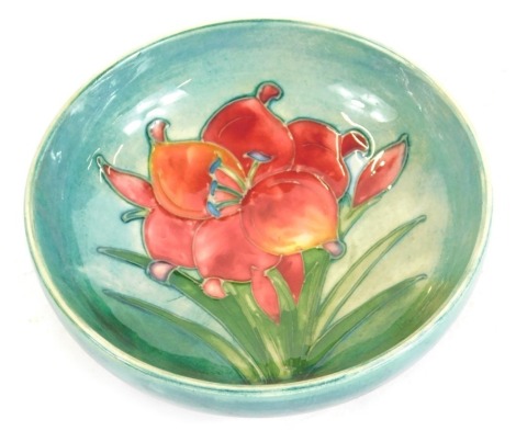 A Moorcroft pottery Freesia pattern dish, blue green ground, impressed marks, 12cm diameter.