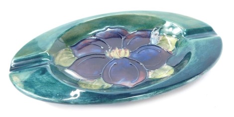 A Moorcroft pottery Anemone pattern ashtray, on a green ground, impressed marks, 15.5cm diameter.