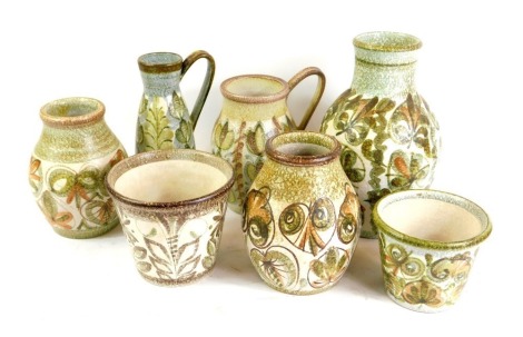 Seven Denby Glynn Colledge vases and jugs, each decorated on a green and brown ground with flowers, the largest 29cm high.