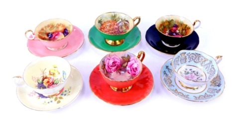 A group of 20thC porcelain tea cups and saucers, comprising an Aynsley cup and saucer decorated with flowers, by B Jones, on a black ground, on a pink ground, a Hammersley china green cup and saucer decorated with pineapple.