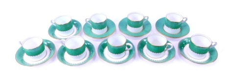 A set of nine early 20thC Coalport porcelain coffee cans and saucers, decorated with a powder green band, gilt heightened, pattern no. 9157, printed marks.