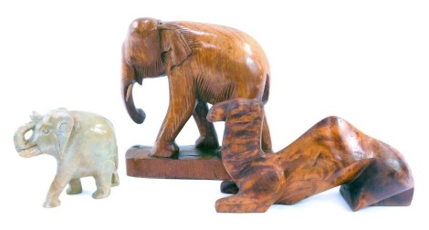 Three animal carvings, comprising a carved wooden elephant, 17cm high, recumbent camel, 11cm high, and a soapstone elephant, 9cm high. (3)