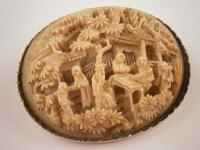 A carved ivory oriental style brooch