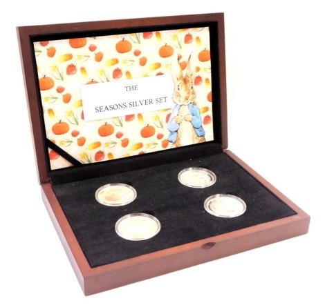 A Peter Rabbit The Four Seasons silver collector's coins set, each enamel decorated for autumn, summer, winter and spring, in fitted case, with limited edition certificate number 63, each coin 1oz of silver.