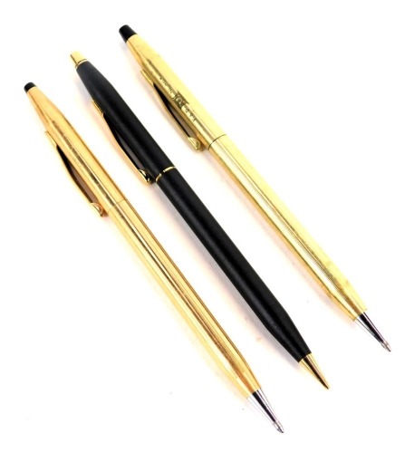 Three Cross ballpoint pens, one in gold coloured casing marked P&D Nigeria, another in rose coloured gold casing, and the other in matt black case. (3)