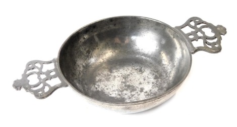 A late 19thC pewter two handled shallow bowl, with pierced and moulded handles, stamped E and England, 18cm wide.