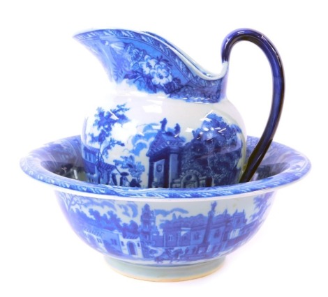 An ironstone blue and white wash jug and bowl set, comprising jug depicting buildings, 21cm high, and a monument centre bowl, 31cm diameter. (2, AF)