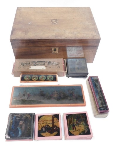 A group of Magic Lantern slides, to include Primus Flies and Moths slides, boxed, biblical scenes, etc., contained in a 19thC mahogany writing slope.