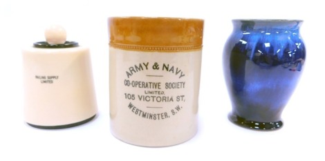 A Bourne Denby Co-operative Society stoneware jar and cover, 13cm high, together with a Grantham Cooperative Society commemorative Diamond Jubilee 1932 blue glaze vase, 13.5cm high, and a Dorset Light Industries flintless Bakelite cased table lighter. (3