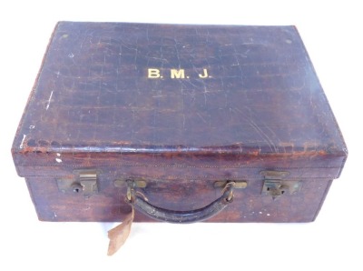 An early 20thC crocodile skin case, stamped BMJ, enclosing a green fitted interior, 51cm wide.