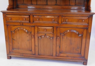 An oak Welsh dresser in 18thC style, the top with a moulded edge with three shelves, the base with three moulded drawers with turned handles, above a central small drawer flanked by two panelled cupboards, on stiles, 200cm high, 152cm wide, 51cm deep. - 2