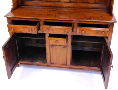 An oak Welsh dresser in 18thC style, the top with a moulded edge with three shelves, the base with three moulded drawers with turned handles, above a central small drawer flanked by two panelled cupboards, on stiles, 200cm high, 152cm wide, 51cm deep. - 4