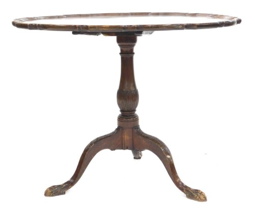 A George III mahogany tilt top, with a later dished piecrust top, raised on a leaf carved baluster column over three leaf carved cabriole legs terminating in ball and claw feet, 70.5cm high, 89cm diameter.