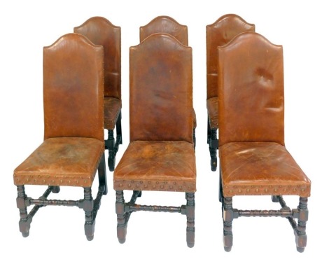 A set of six Artsome for Coach House Collection high back oak dining chairs, each with a brown leather seat and back, with stud work, raised on turned legs united by stretchers.