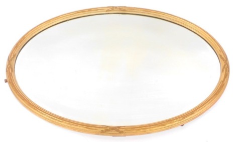 A gilt wood oval wall mirror, with reeded border intersected with cross decoration, 56cm x 80cm.