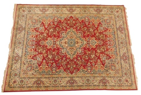 A machine woven Persian style carpet, decorated with flowers etc., on a red ground, 250cm x 350cm.