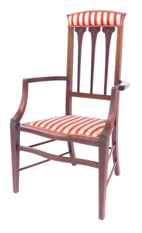 An Edwardian mahogany and box wood line inlaid open armchair, with over stuffed upholstered regency stripe rail, and floral carved vase shaped splats, with a regency stripe over stuffed seat, on square tapering legs united by stretchers.