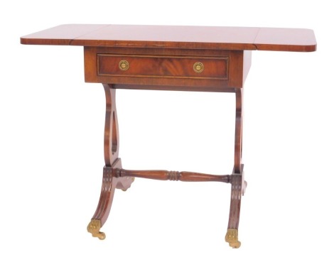 A 20thC mahogany small drop leaf occasional table in Regency style, with frieze drawer raised on harp shaped supports united by a turned stretcher, on splayed legs with brass lion paw capped castors, 53cm high, 45cm wide, 74cm extended, 38cm deep.