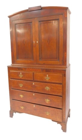 A George III oak and inlaid cabinet on chest, the top with an arched top above two panelled doors inlaid with shell patera, the base with a moulded edge above two short and three long drawers, on bracket feet, 232cm high, 122cm wide, 56cm deep.