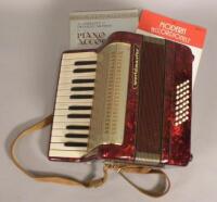 A Worldmaster piano accordion in dark red simulated marble case