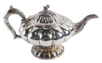 A Victorian silver teapot, with a fluted and moulded body, with an acanthus leaf spout, and floral cluster to centre on a shaped handle, with ivory insulators, maker J A, London 1868, 24.04oz gross. (AF)