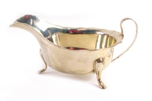 A George VI silver sauce boat, with a fluted border, on three feet, stamped Sheffield, maker EV, Sheffield 1949, 3.33oz.