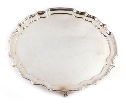 A 20thC silver plated salver, with piecrust border, on four ball and claw feet, stamped EPNS, 35cm diameter.