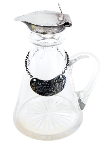 A George V miniature cut glass whisky jug, with a silver top and label marked whisky, with rubbed hallmarks, on a star cut glass base, 10cm high.