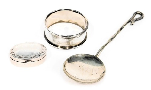 Silverwares, comprising a silver napkin ring of engine turned design, a white metal oval pill box, bearing the initials GPP, white metal stamped 925, and a white metal serving spoon rubbed marks, 1.23oz. (3)