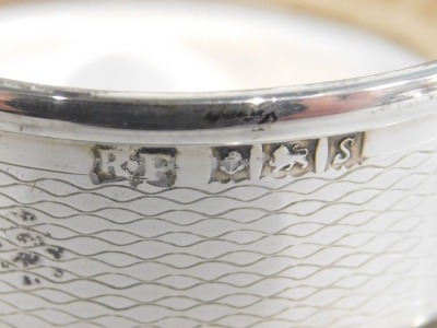 Silverwares, comprising a silver napkin ring of engine turned design, a white metal oval pill box, bearing the initials GPP, white metal stamped 925, and a white metal serving spoon rubbed marks, 1.23oz. (3) - 2