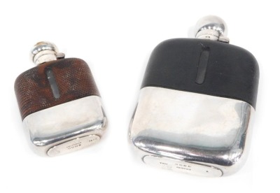 Two hip flasks, each part leather base, with a stainless steel top, one stamped JD&S Sheffield, 17cm high, another smaller example, 11.5cm high. (2)