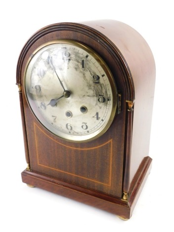 An Edwardian mahogany and boxwood strung mantel clock, the arched case with gilt metal mounts, silvered dial and Westminster chime, 34cm high.