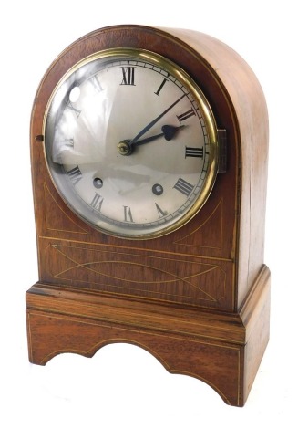 A 19thC mahogany and boxwood strung mantel clock, with a silvered dial, and an arched case, 30cm high.