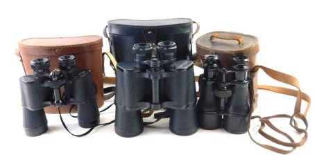 A pair of military issue binoculars, with leather case stamped Baltic Leather Goods Company 1916, and two other pairs of binoculars.