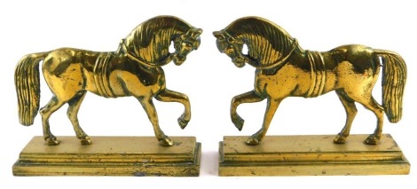 A pair of 19thC brass hearth ornaments, modelled in the form of horses, each on a rectangular base, 27cm wide.