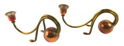 A pair of Arts and Crafts copper and brass candlesticks, each with a weighted globular end, shaped legs and arm in the manner of Benson (AF) 22cm long.