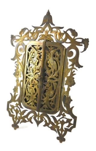 A late 19th/early 20thC pierced brass frame, with two hinged doors, on an easel support, 18cm high.