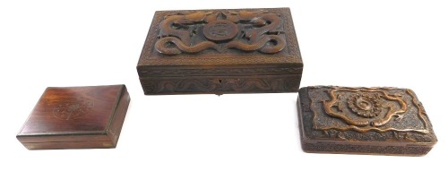 An Eastern hardwood cigarette or cigar box, carved with dragons surrounding a central monogram S.A?, 29cm wide, Indian brass inlaid box, and a further box carved with snakes etc. (3)