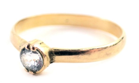 A solitaire ring, set with round brilliant cut imitation diamond, in double four claw setting, on a plain band, yellow metal unmarked, ring size P½, 1.5g all in.