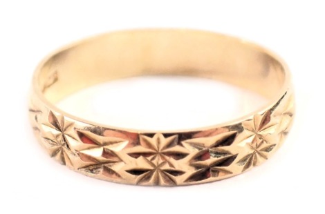 A 9ct gold wedding band, of hatched star design, bearing internal inscription WR34M1282, ring size N½, 1.5g all in.