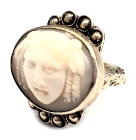 An unusual silver dress ring, the ring head set with oval cameo of Medusa, with a four beaded petalated border, on a raised and altered mount, the band stamped 925 DEA, ring size K½, 8.1g all in.