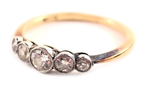 A five stone diamond dress ring, the diamonds in rub over platinum setting of graduated design, the central stone approx 0.20ct, the outer halos 0.10ct, and 0.030ct, set in platinum on a yellow metal band stamped 18ct, ring size P½, 2.2g all in.