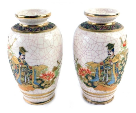 A pair of Japanese Earthenware vases, each decorated with figures in elaborate costume, picked out in gilt, on a crackled ground, signed to base, 20cm high.