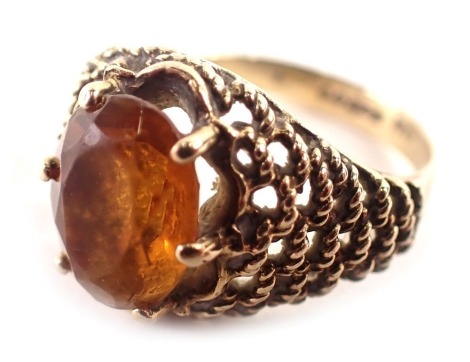 A 9ct gold dress ring, with an oval citrine in a six claw setting, with rope twist layered borders, ring size O, 3.2g all in.